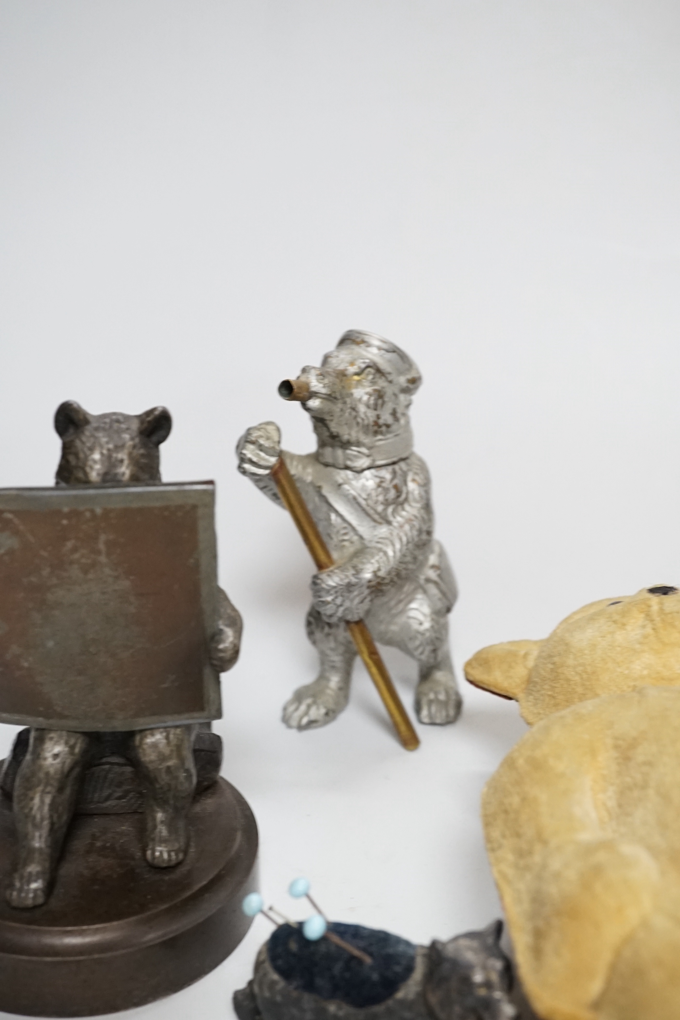 Four metal bear pin cushions, a money box, a bear stud box, three metal bears, a mother of pearl metal bear dish and an advertising bear on a box